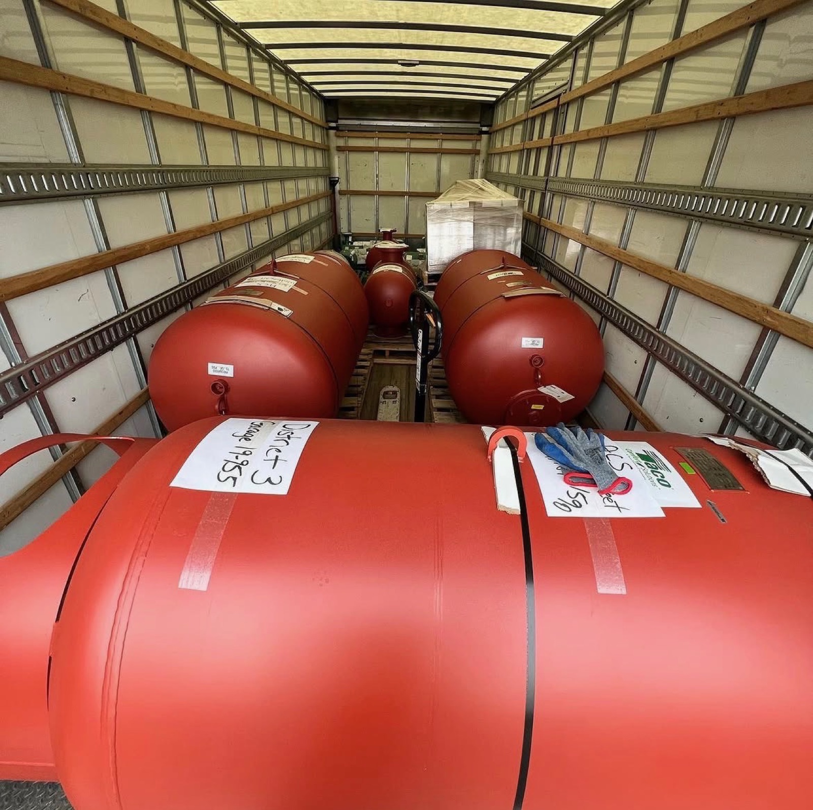 Large red pressure tanks strapped down inside a F. Bonavise box truck